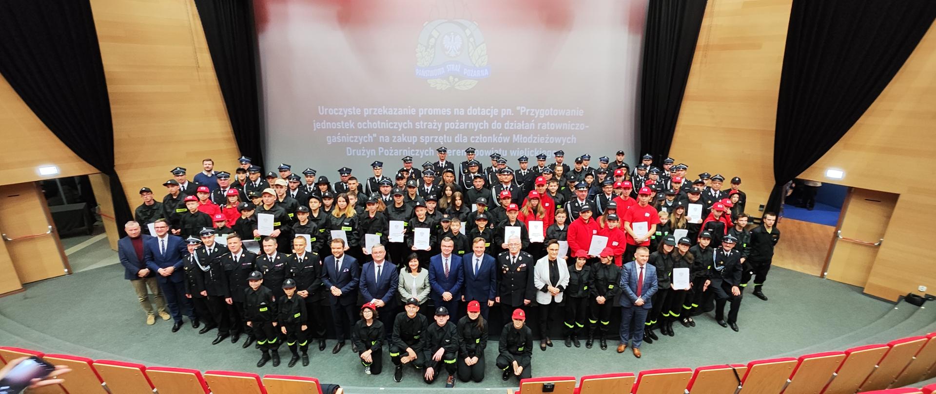 Zdjęcie grupowe młodzieżowych drużyn pożarniczych wraz z opiekunami oraz zaproszonymi gośćmi