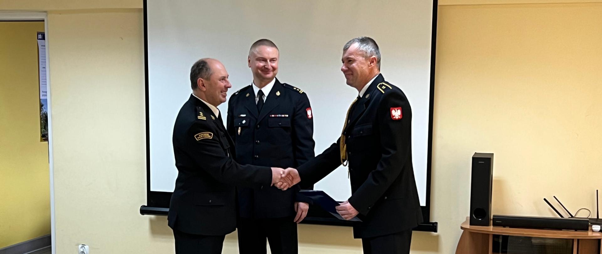 Trzech mężczyzn ubranych w umundurowanie wyjściowe, Mężczyźni składają gratulacje z okazji odejścia na zaopatrzenie emerytalne