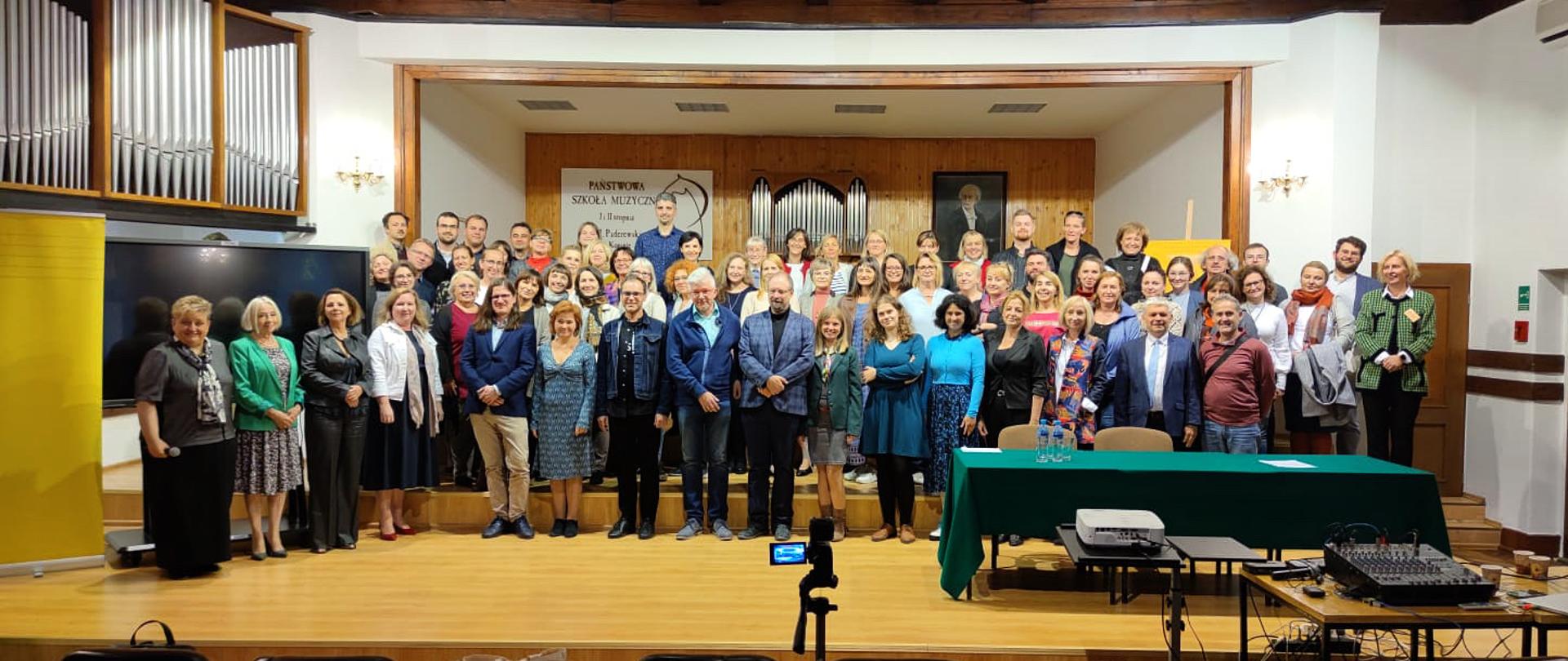 Uczestnicy, organizatorzy i wykładowcy stoją na scenie PSM w Koninie