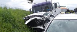 Na zdjęciu widać trzy samochody, które brały udział w wypadku drogowym. Samochód ciężarowy znajduje się na samym końcu przed nim jest samochód osobowy z uszkodzonym przodem. W prawym dolnym rogu widać jeszcze jeden samochód osobowy. Wszystkie pojazdy znajdują się w przydrożnym rowie. W tle widać strażaków oraz karetkę pogotowiaNa zdjęciu widać trzy samochody, które brały udział w wypadku drogowym. Samochód ciężarowy znajduje się na samym końcu przed nim jest samochód osobowy z uszkodzonym przodem. W prawym dolnym rogu widać jeszcze jeden samochód osobowy. Wszystkie pojazdy znajdują się w przydrożnym rowie. W tle widać strażaków oraz karetkę pogotowia