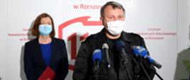Na zdjęciu widać Podkarpackiego Komendanta Wojewódzkiego Państwowej Straży Pożarnej nadbryg. Andrzeja Babca udzielającego wywiadu przy mikrofonie. ubrany jest w umundurowanie dowódczo-sztabowe i maskę.