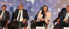 wiceminister Małgorzata Jarosińska-Jedynak mówi do mikrofonu, pozostali paneliści słuchają