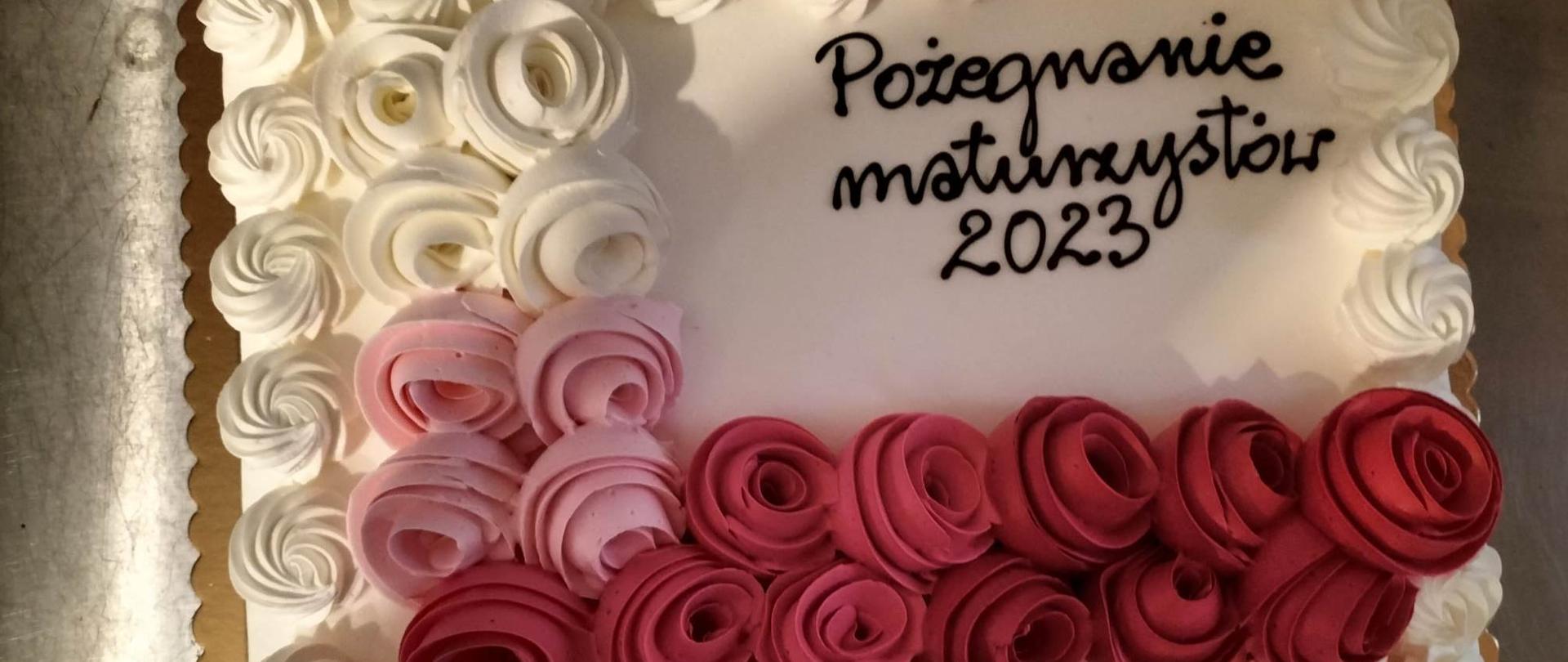 Tort przyozdobiony różami z napisem - Pożegnanie Maturzystów. 