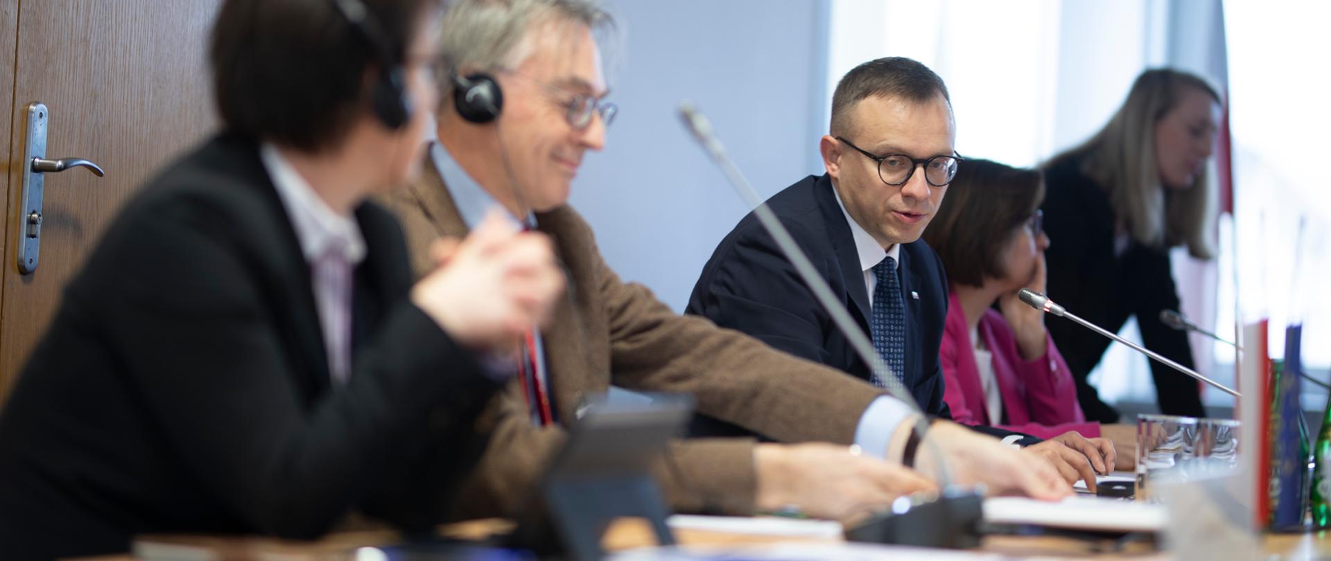 przy stole siedzą uczestnicy spotkania, w środku wiceminister Artur Soboń