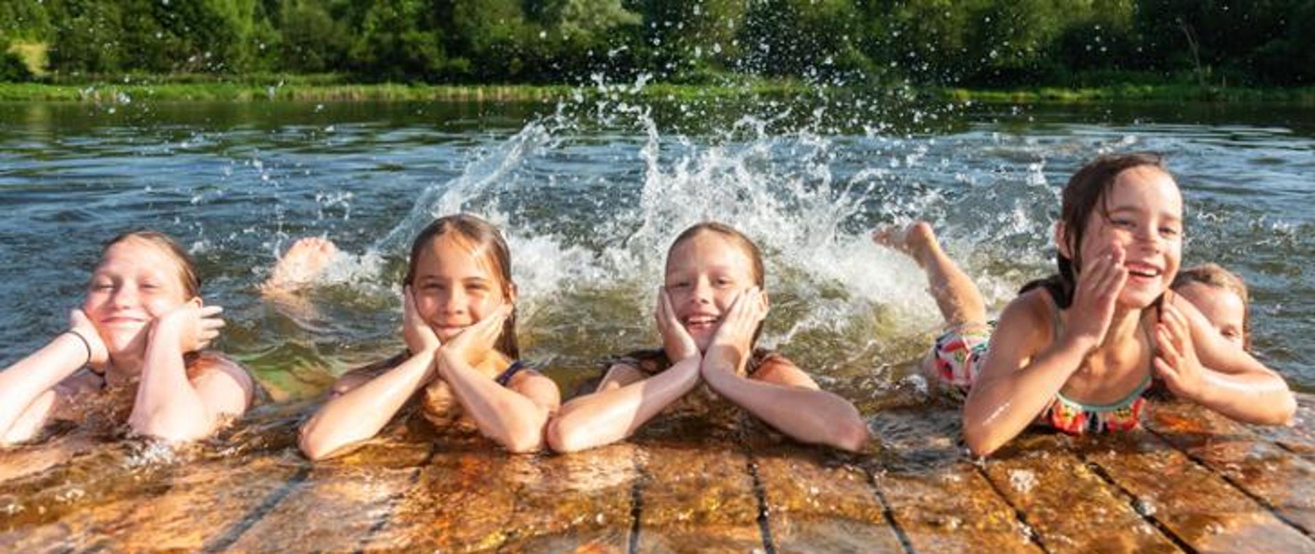 zdjęcie przedstawia kąpiących się w jeziorze