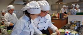 Grupa uczniów Technikum Żywienia i Usług Gastronomicznych w strojach kucharskich podczas zajęć praktycznych