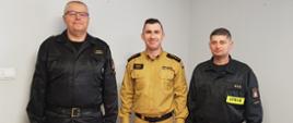 Zdjęcie przedstawia trzech strażaków pozujących do zdjęcia. Są to komendant, dowódca JRG oraz p.o. zastępca dowódcy JRG.