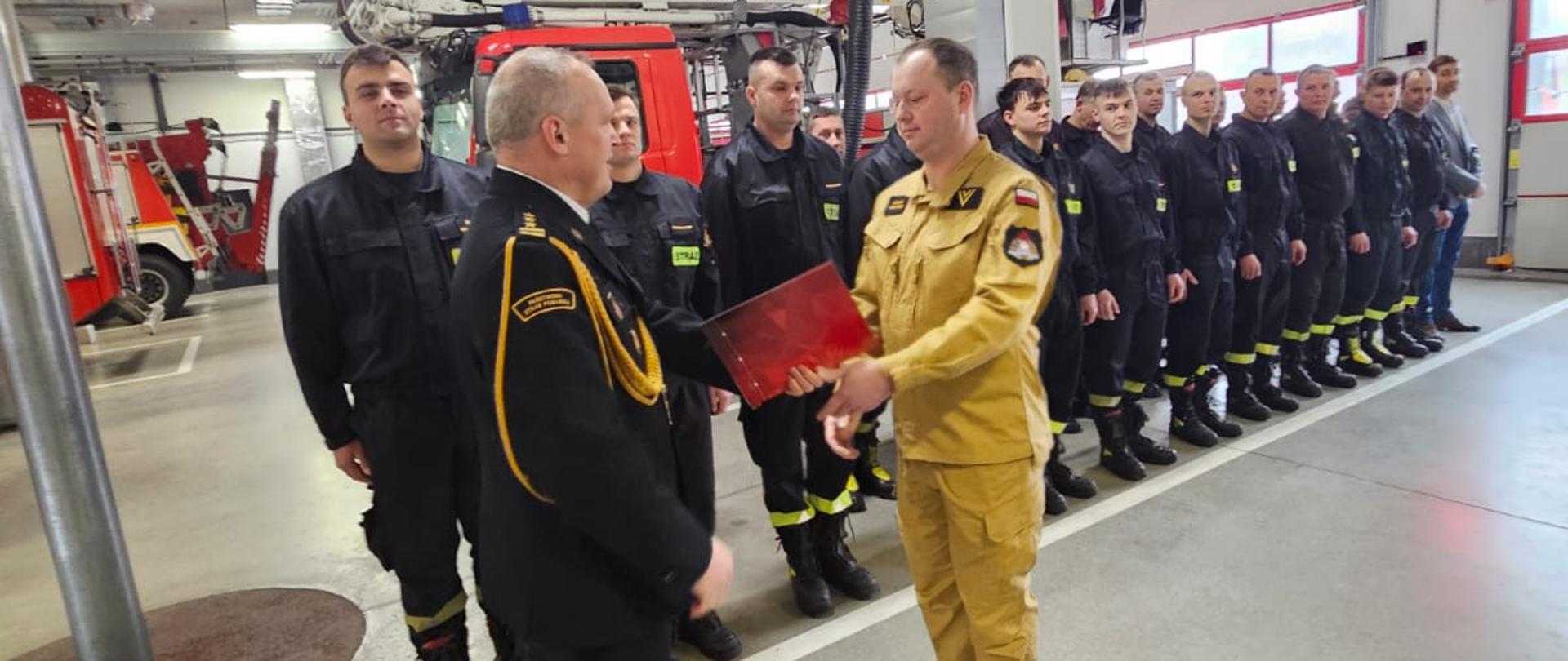 Komendant wręczający nagrodę jubileuszową.