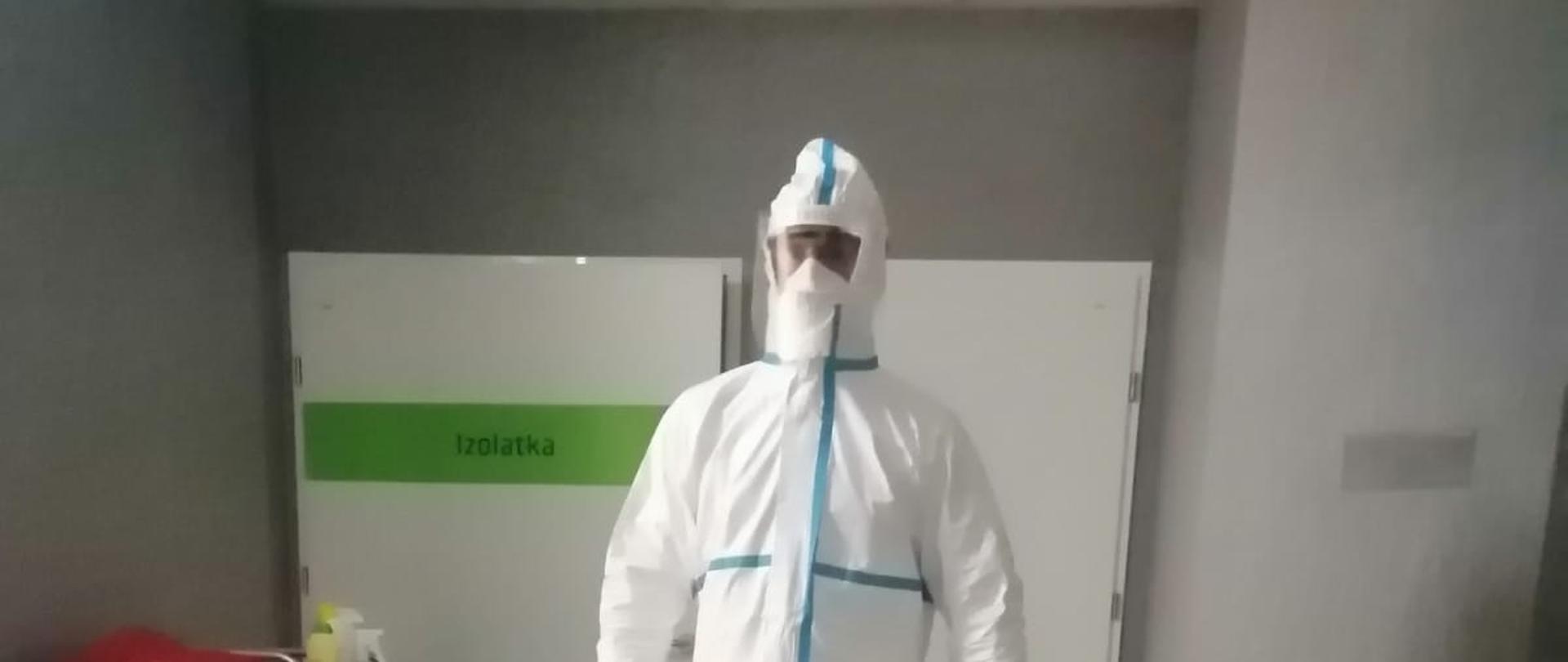 Na zdjęciu ratownik Państwowej Straży Pożarnej w szczelnym stroju ochronnym osłaniającym całe ciało.