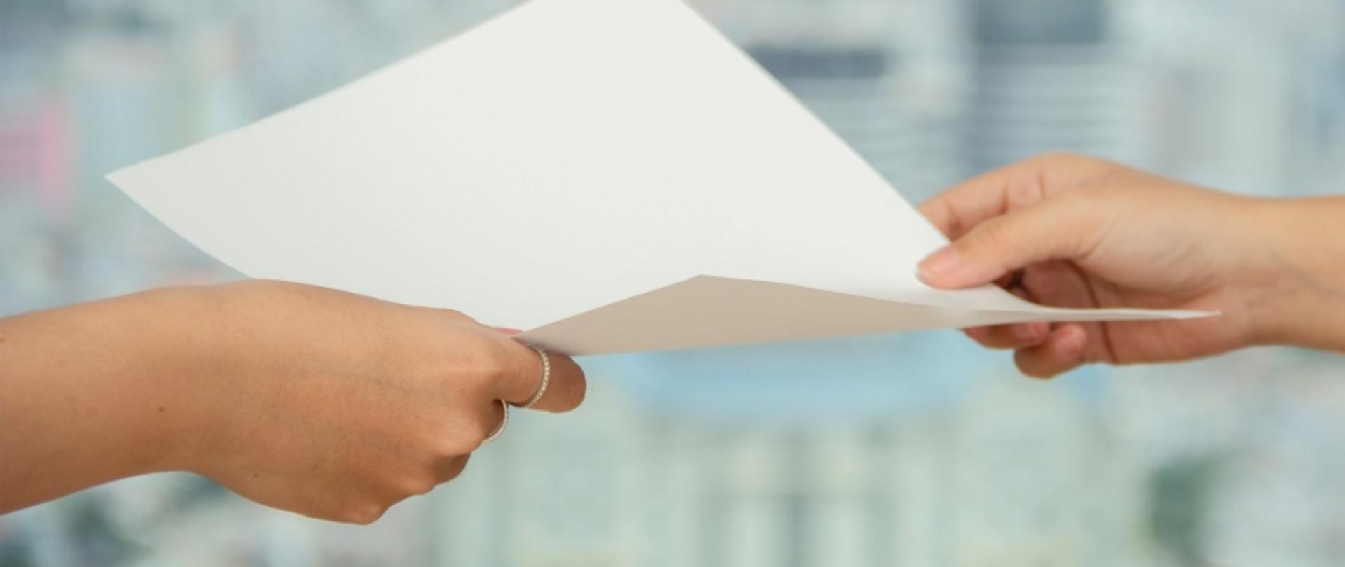  Przekazywanie kartki papieru między dwiema osobami.