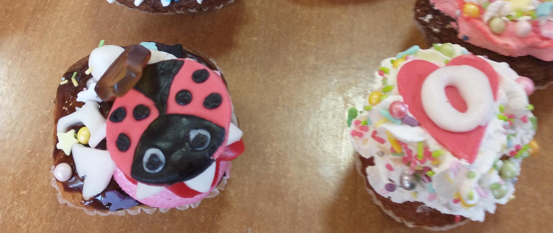 Babeczki z kolorowymi ozdobami, na jednej ozdoba w postaci biedronki.