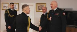 Komendant główny PSP podaje rękę dotychczasowemu zastępcy podlaskiego komendanta wojewódzkiego, za nimi stoją nowy zastępca komendanta wojewódzkiego i komendant wojewódzki