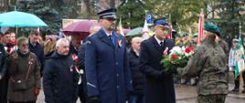 Funkcjonariusze Policji oraz Państwowej Straży Pożarnej składają kwiaty pod pomnikiem