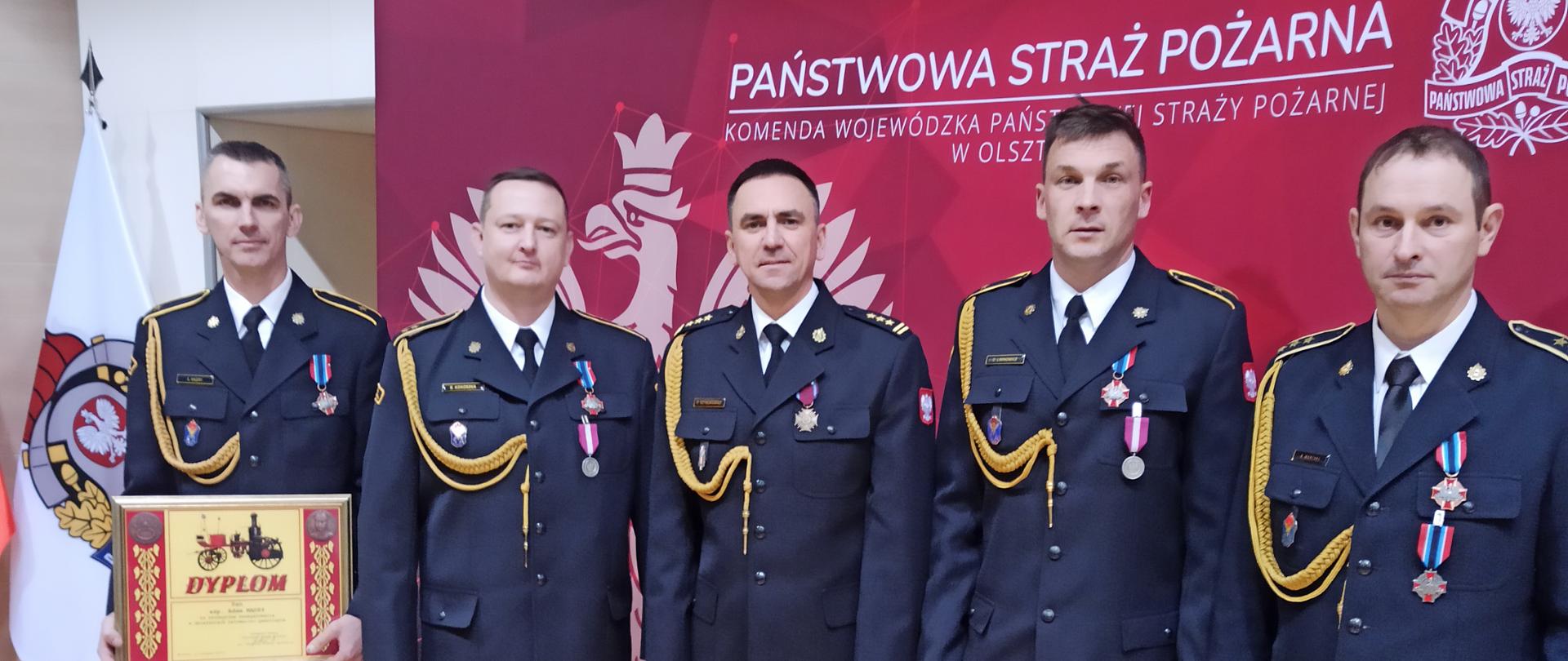 Zdjęcie przedstawia pięciu funkcjonariuszy lidzbarskiej straży po uroczystości wręczenia medali, odznaczeń i wyróżnień 