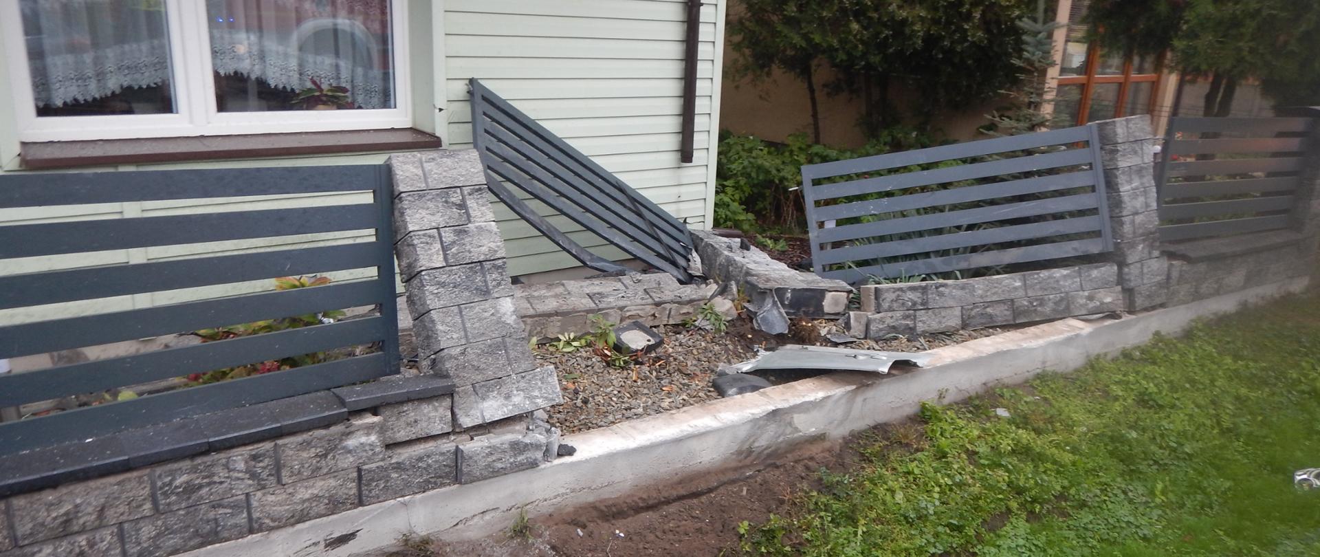 Zdjęcie przedstawia uszkodzony płot