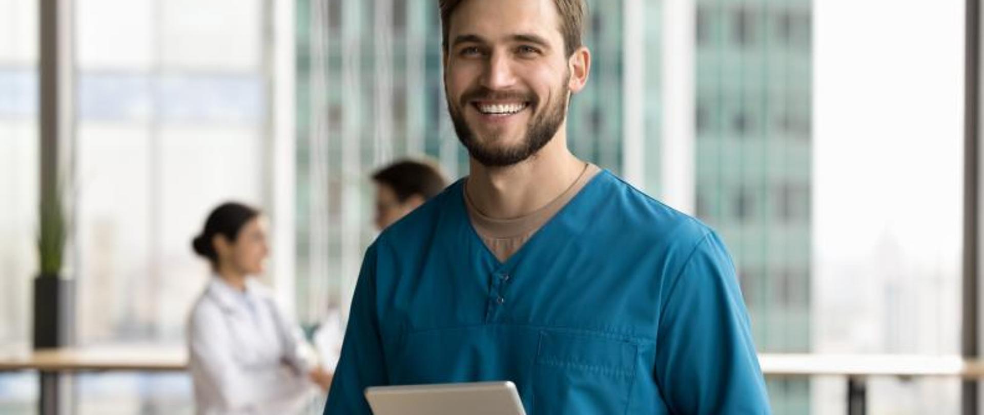 Fotografia przedstawiająca lekarza z tabletem w rękach