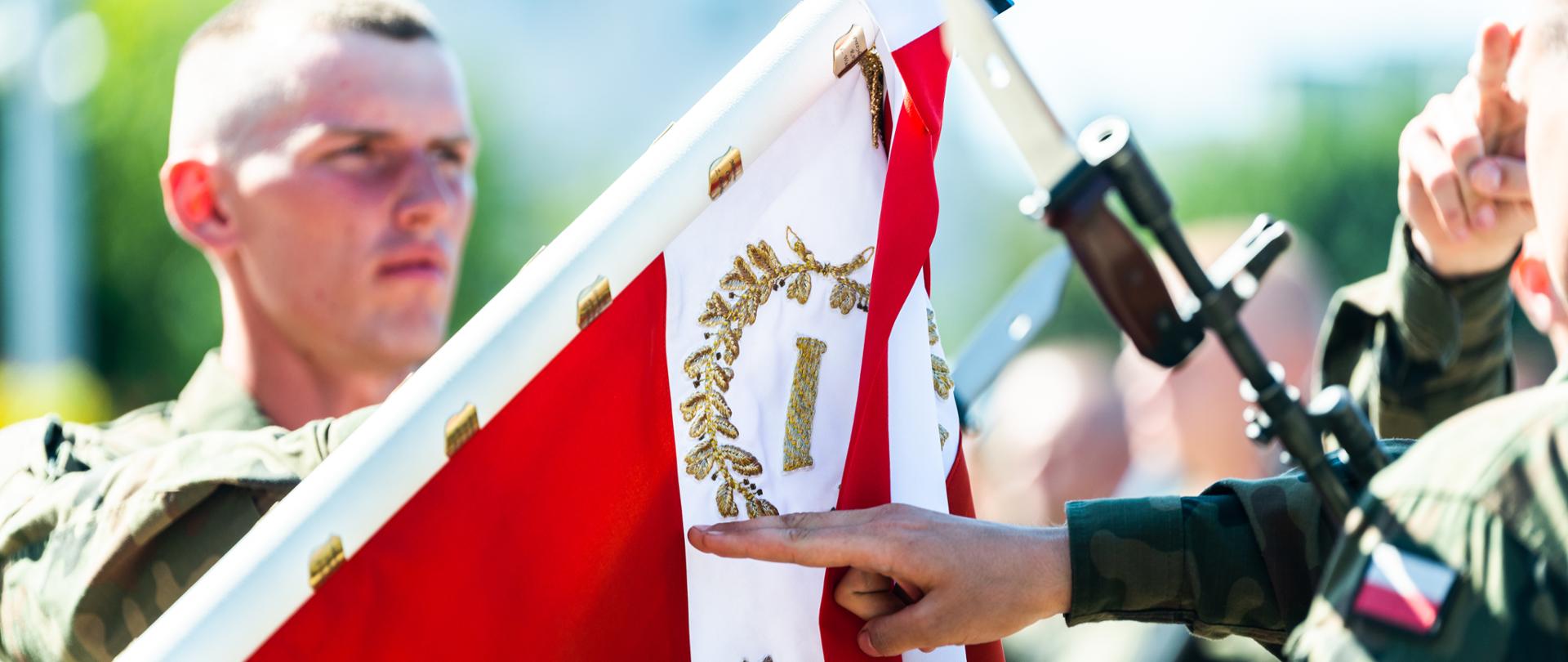 zbliżenie na sztandar i ręce przysięgających żołnierzy