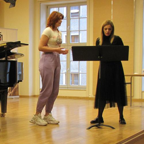 Zdjęcie orzedstawia uczestników i prowadzących w czasie warsztatowych zajęć wokalnyc