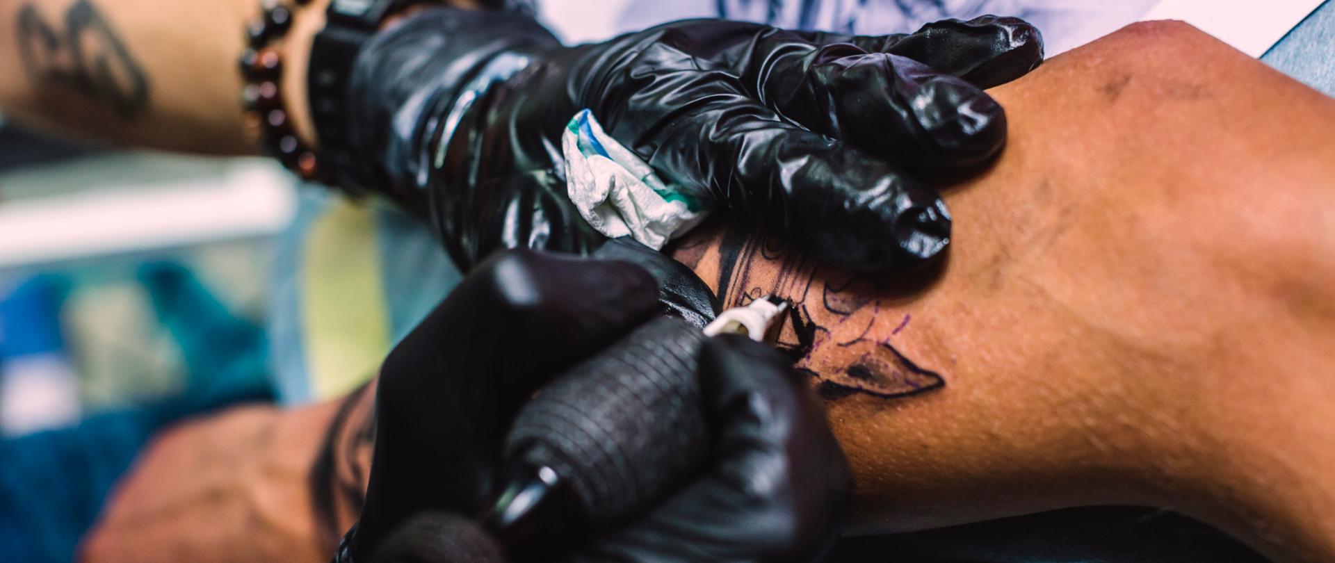 Tatuowana ręka przez tatuażystę