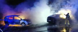 Pora nocna. Duże zadymienie. Widać funkcjonariuszy. Palą się dwa auta.