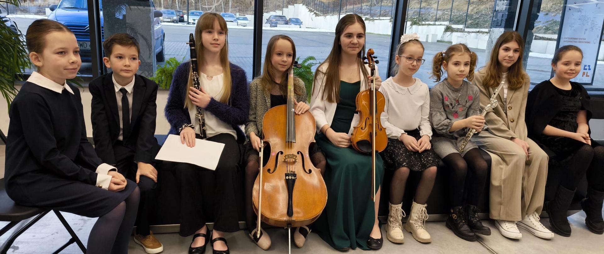 Grupa uczniów z instrumentami w rękach czeka na występ