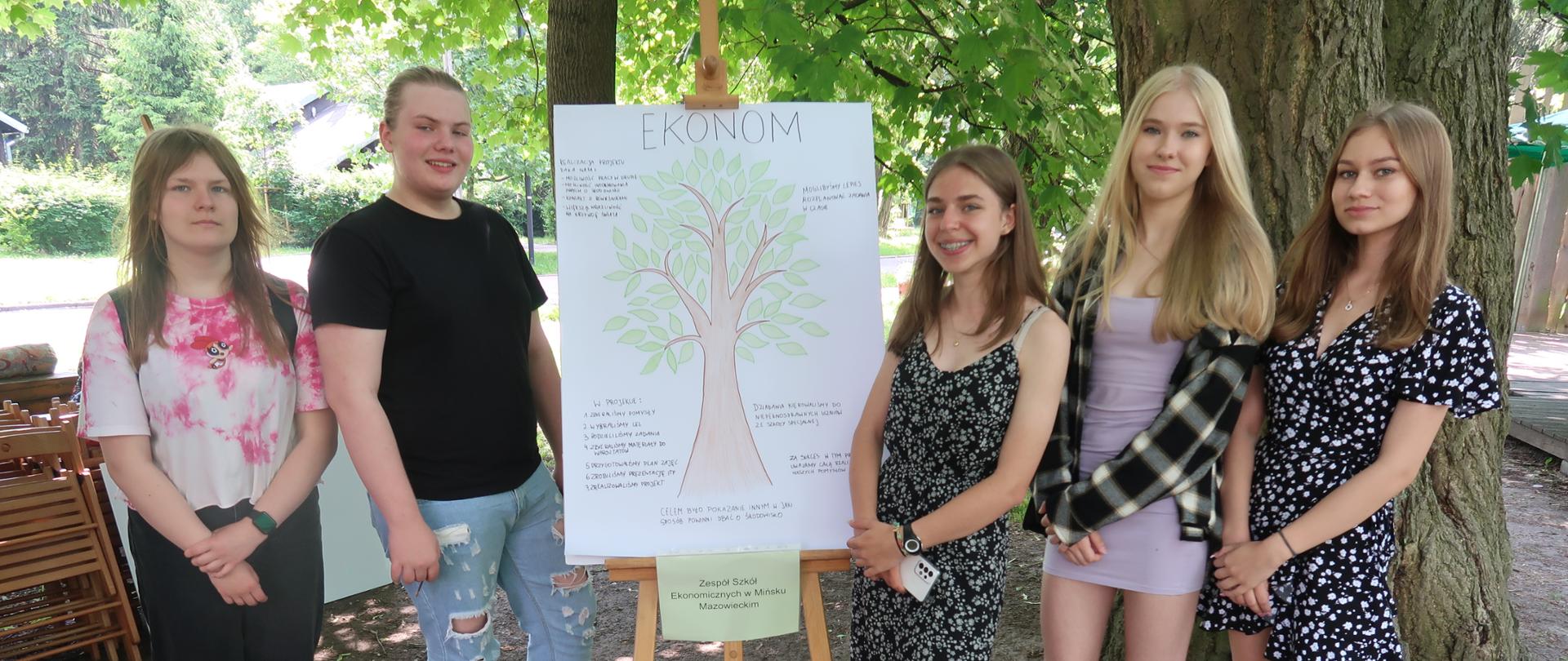 Uczniowie prezentują planszę z napisem "Ekonom" i narysowanym drzewem