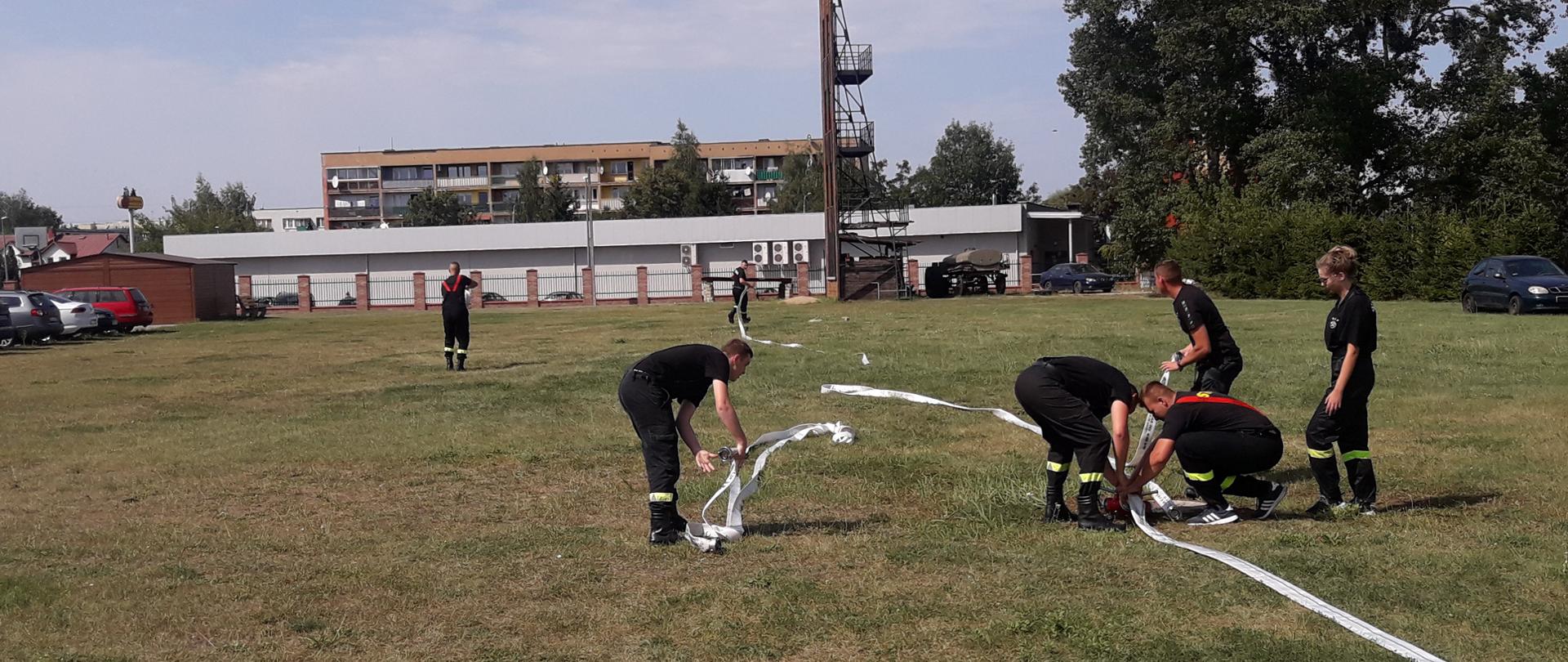 Strażacy OSP w trakcie zajęć praktycznych z rozwijania węży.