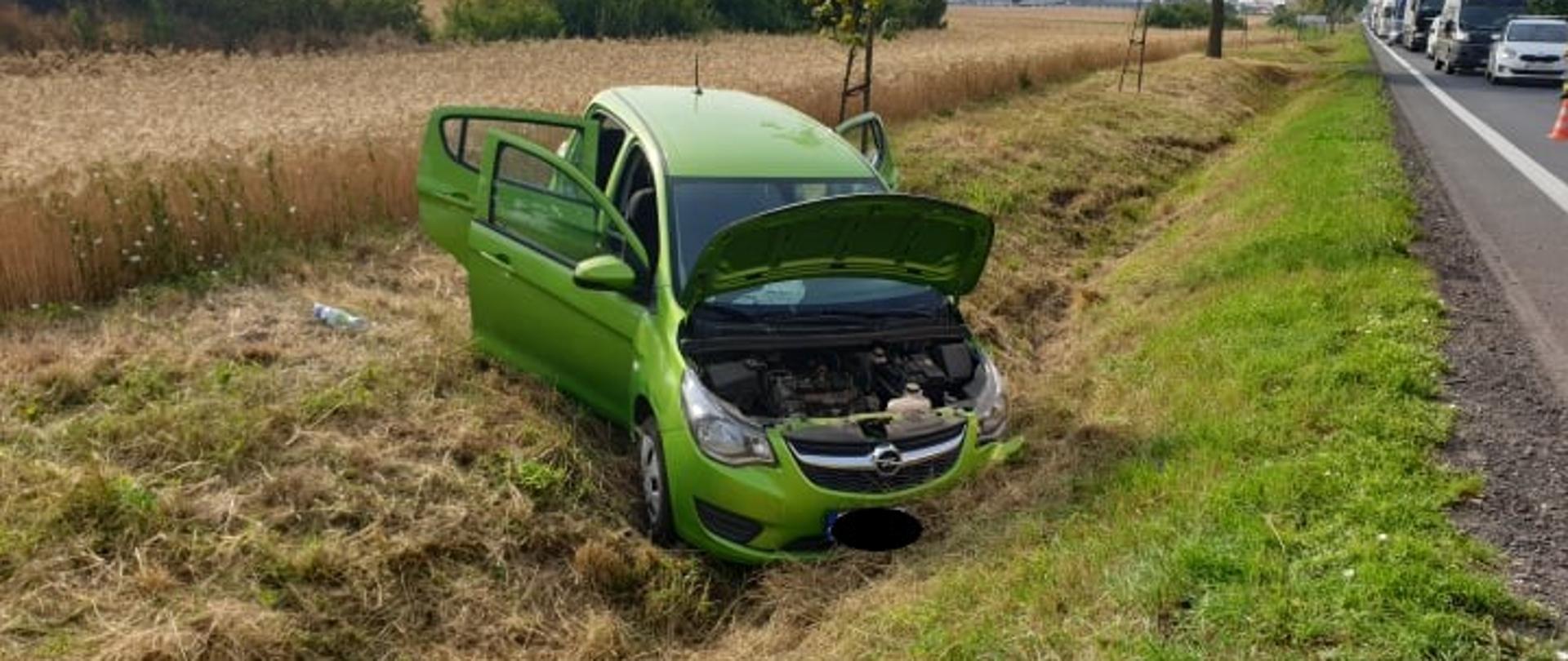 Zdjęcie przedstawia samochód osobowy znajdujący się w przydrożnym rowie.