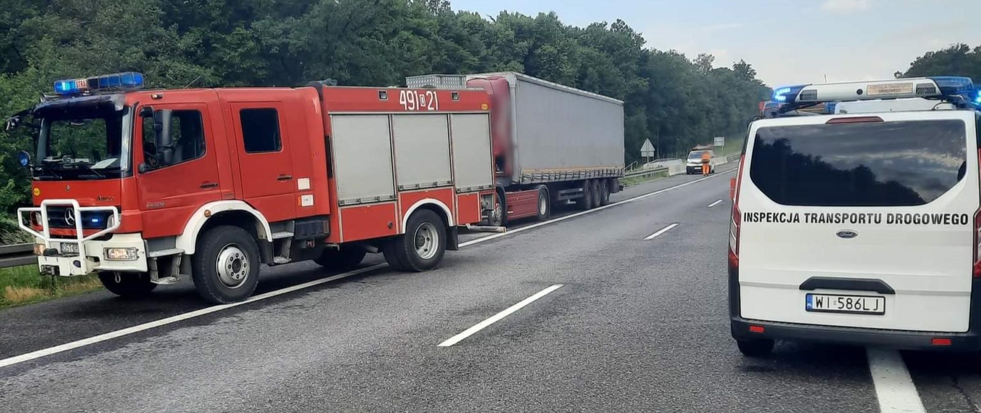 Oznakowany radiowóz ITD, wóz gaśniczy Straży Pożarnej i ciężarówka stojąca na pasie awaryjnym autostrady A4.
