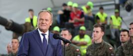 Premier Donald Tusk na tle żołnierzy i sprzętu wojskowego