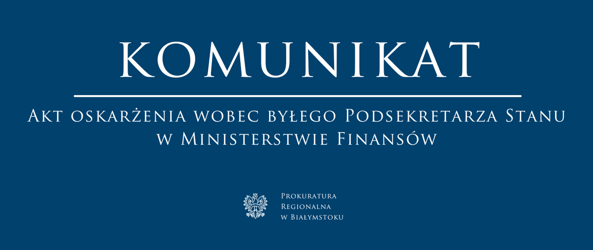 Ciemnoniebieski baner z białym napisem „Komunikat” oraz informacją o akcie oskarżenia wobec byłego podsekretarza stanu w Ministerstwie Finansów. Na dole widoczne godło państwowe i nazwa Prokuratura Regionalna w Białymstoku.