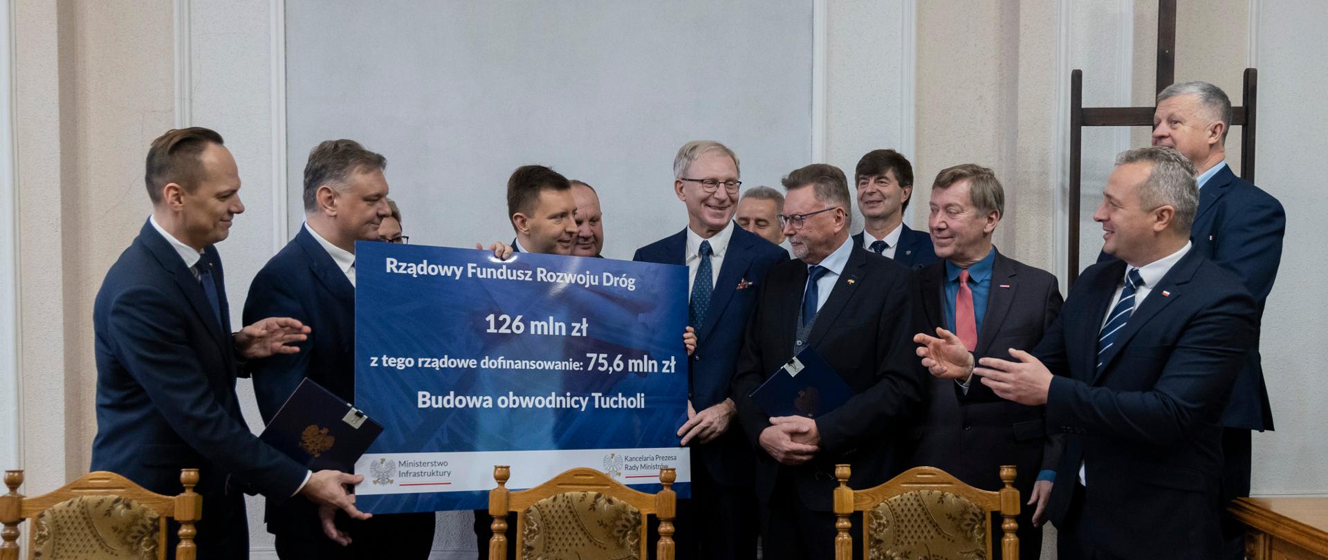 
Grupa osób stojąca w sali konferencyjnej
