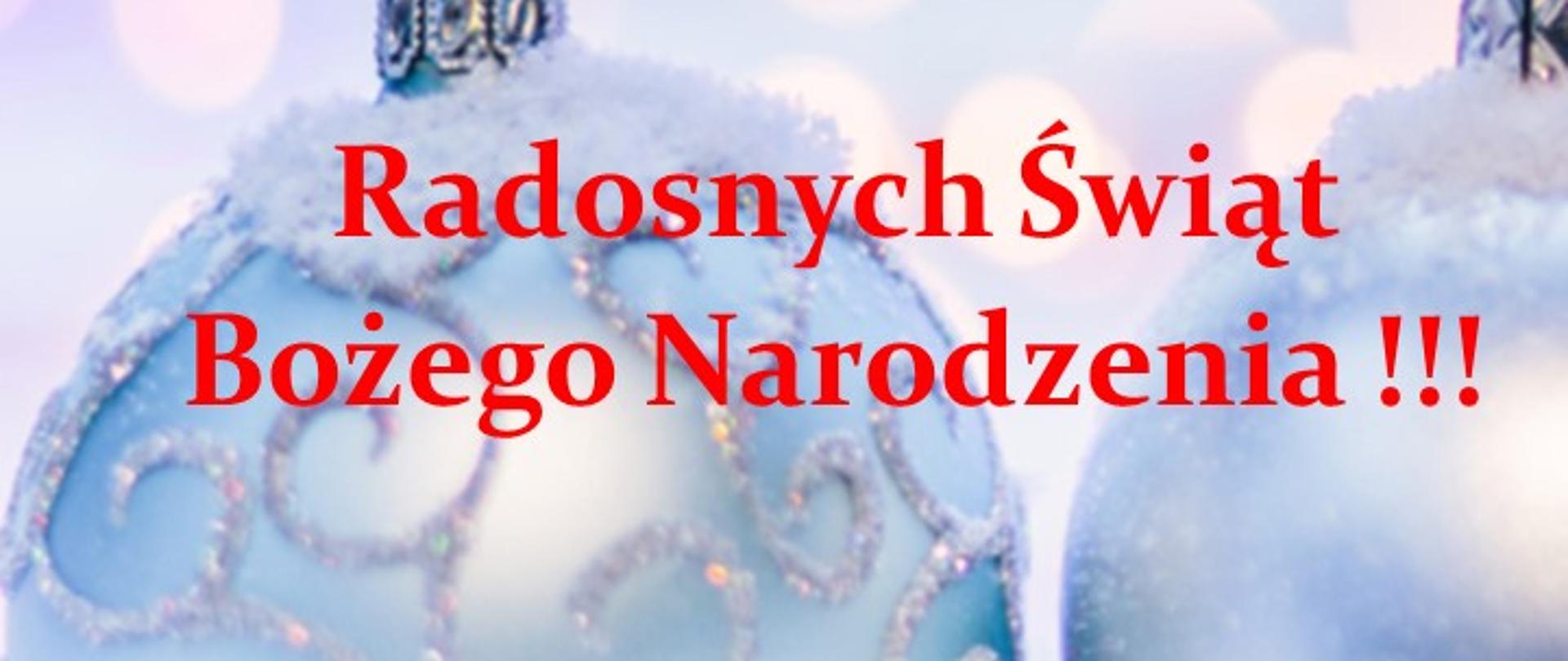 Plakat z życzeniami - napisem Radosnych Świąt Bożego Narodzenia!!!, w tle znajdują się bombki choinkowe leżące na śniegu od których bije poświata w kolorach niebiesko-fiolotetowym