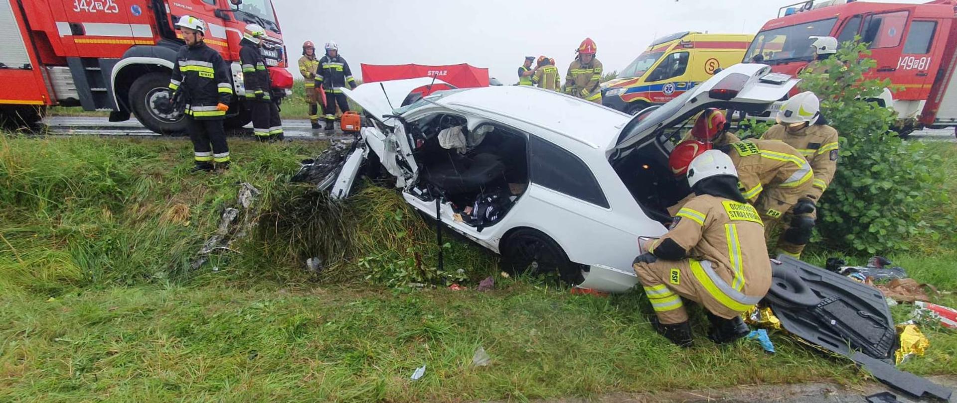 Rozbity samochód, kolor biały, ratownicy, droga