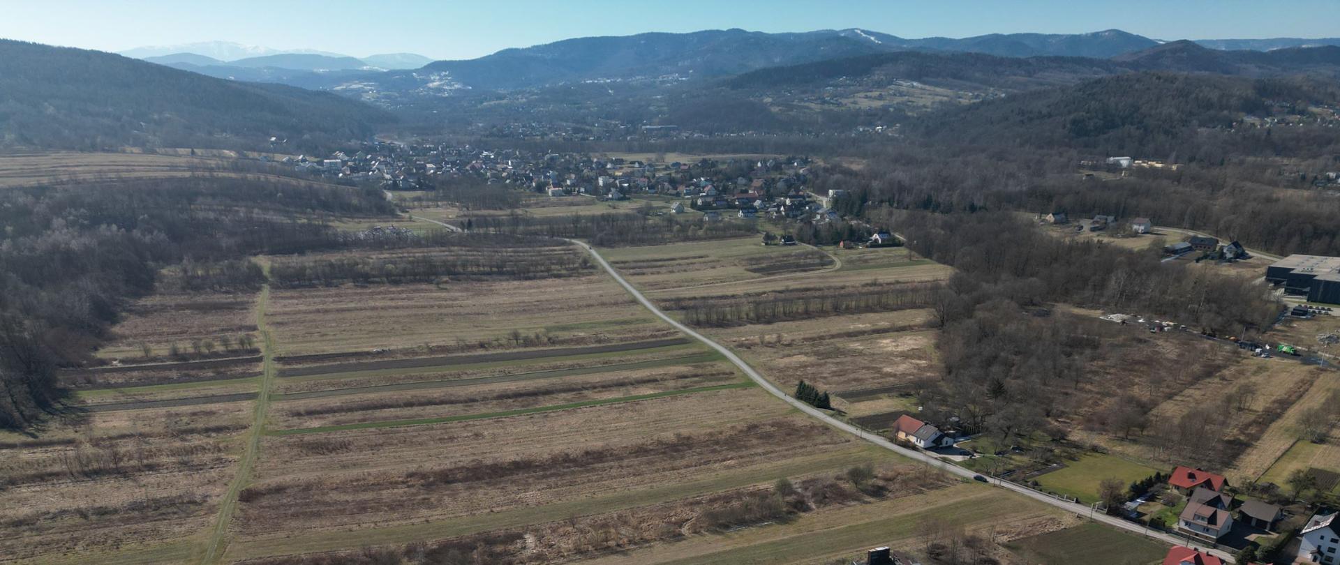 Węzeł Jaroszowice, w centralnej części zdjęcia pola, w dolnej części droga krajowa nr 52, w oddali zabudowania, w perspektywie Beskidy. Zdjęcie lotnicze