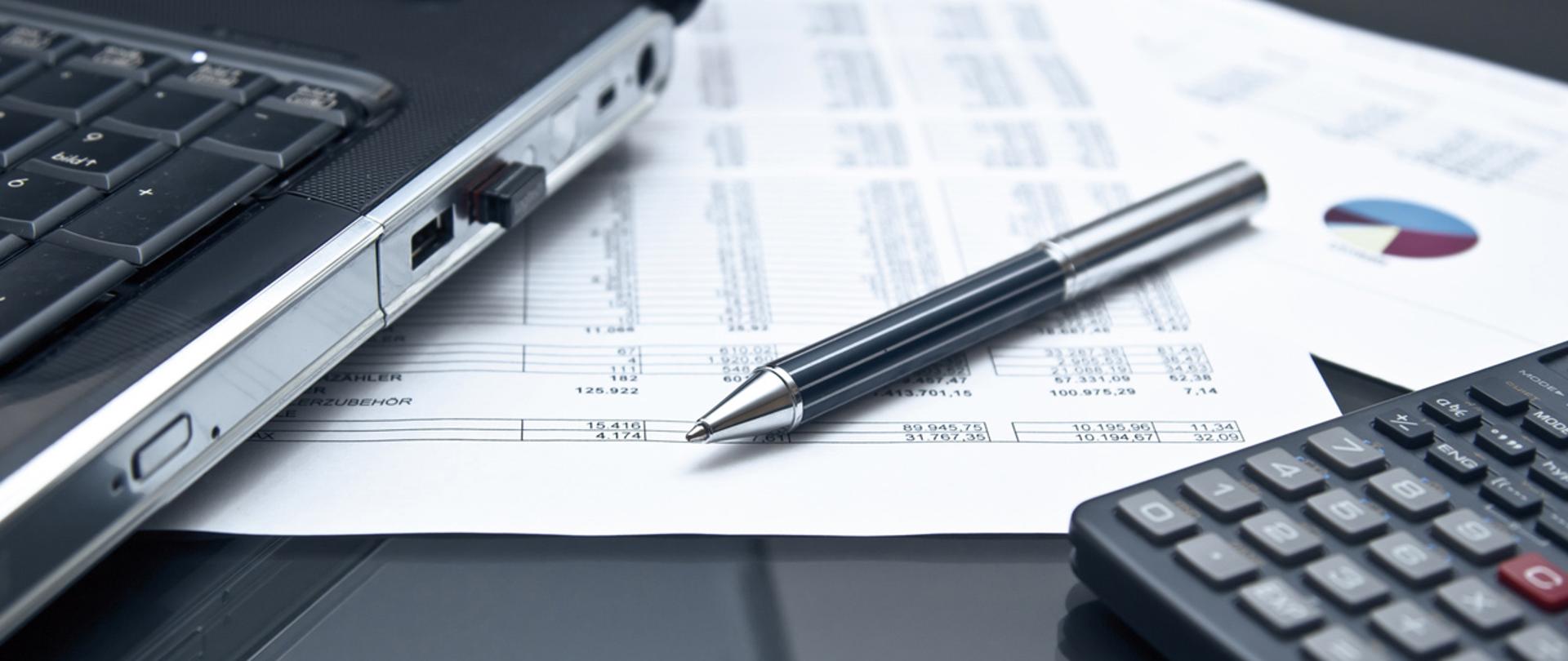 Długopis, kalkulator na dokumentach.