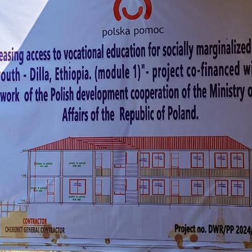 Tablica z projektem szkoły, informacją po angielsku o współfinansowaniu projektu przez MSZ oraz z logo Polskiej pomocy