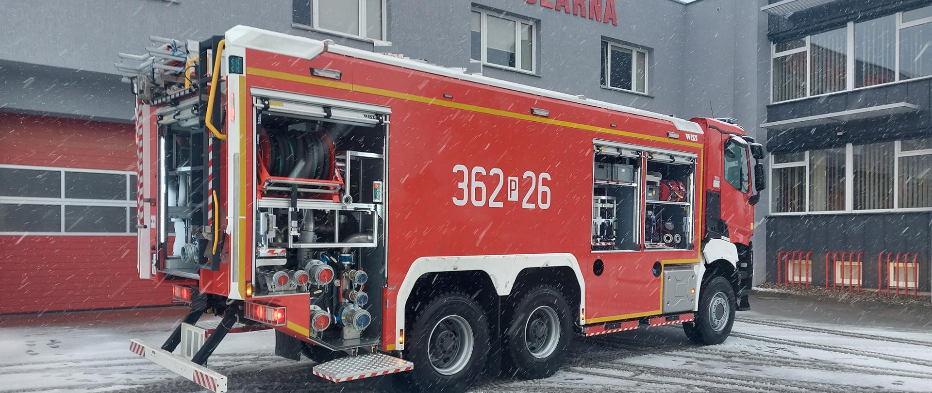 Nowy samochód ratowniczo - gaśniczy. Samochód stoi na placu przed komendą. Skrytki są otwarte. 