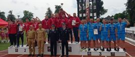 Zdjęcie przedstawia podium zawodów w konkurencji pożarnicze ćwiczenie bojowe. na najniższym stopniu podium strażacy z krośnieńskiej komendy.