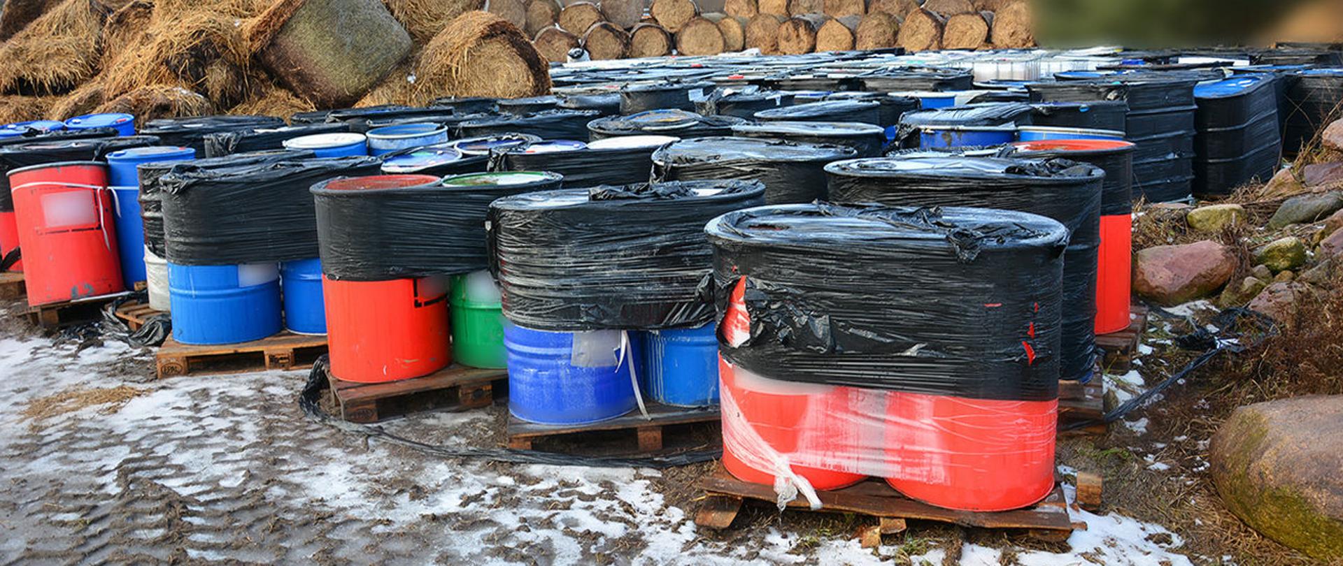 Beczki z odpadami na paletach.