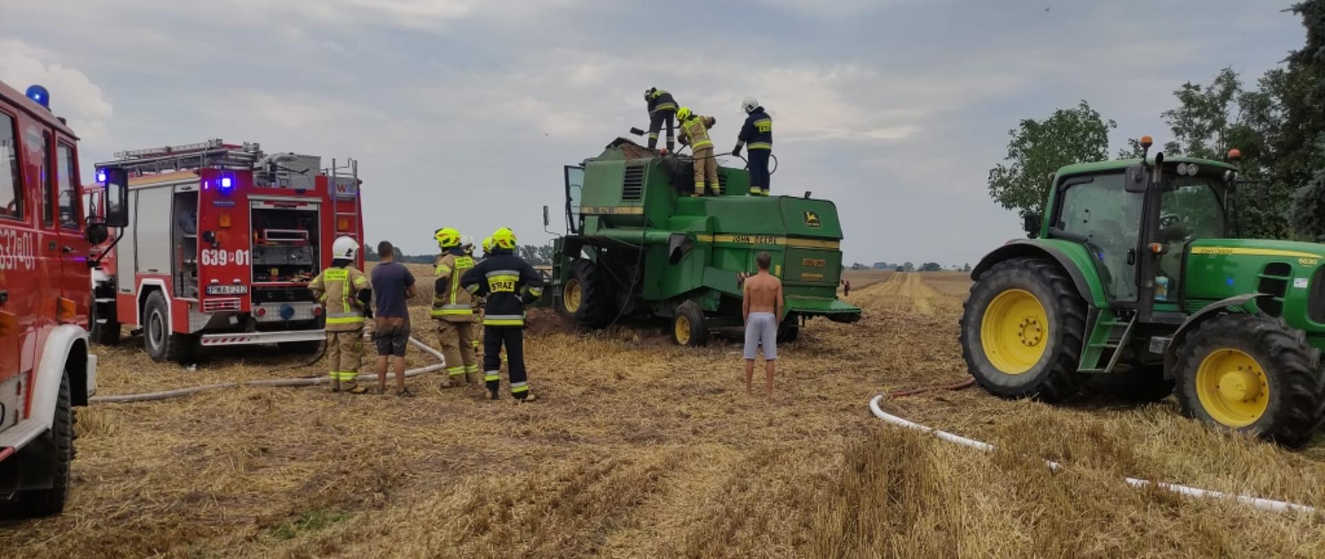 Na zdjęciu widać maszyny rolnicze oraz pojazdy strażackie i strażaków działających 