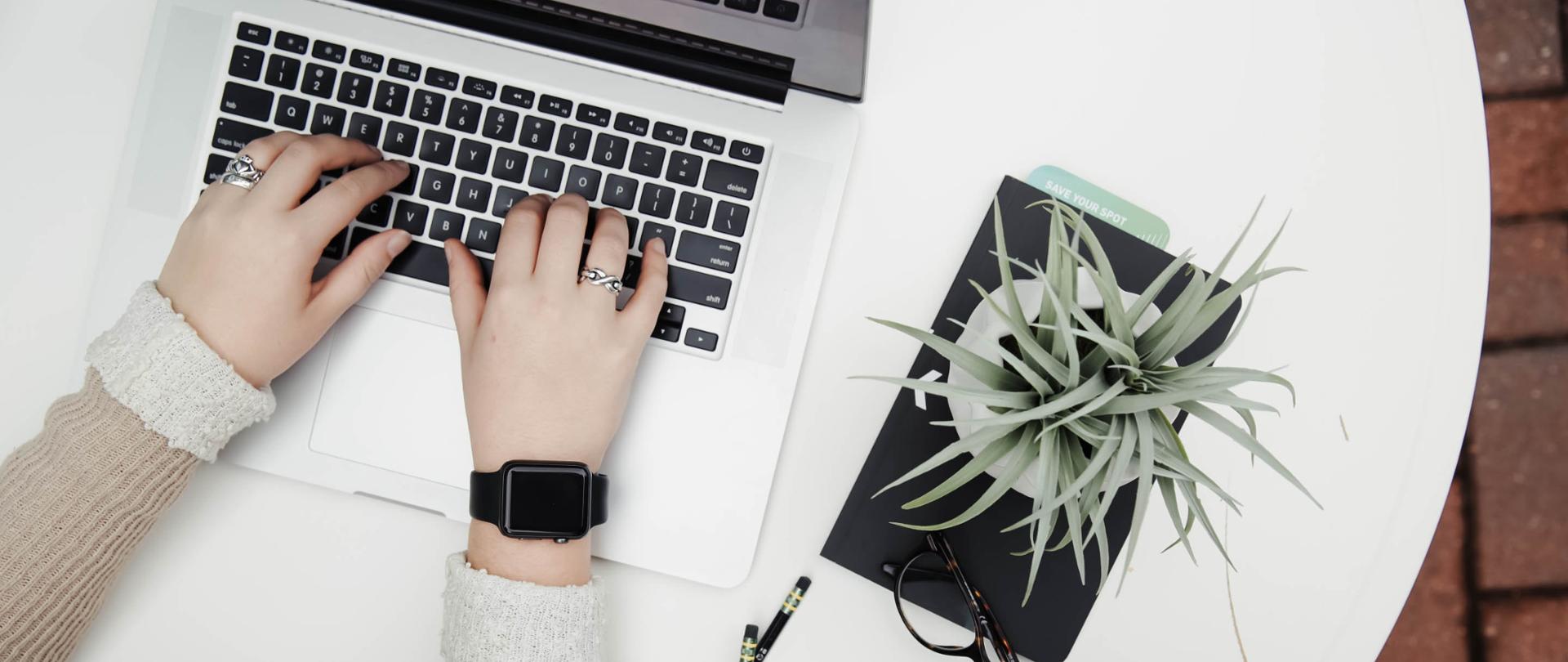 Zdjęcie - klawiatura komputera i ręce kogoś, kto pisze.