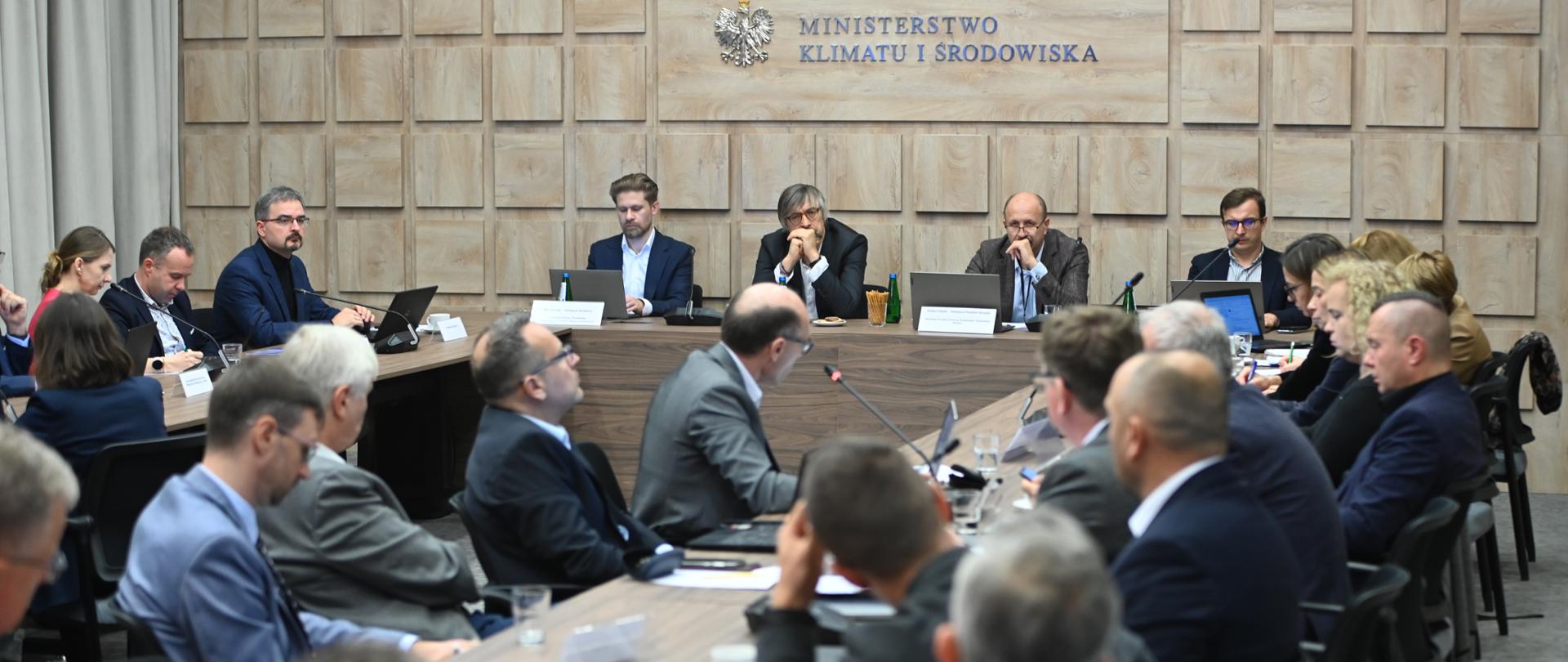 Konsultacje społeczne dotyczące programu Czyste Powietrze w Ministerstwie Klimatu i Środowiska - w sali konferencyjnej siedzą przedstawiciele ministerstwa, Narodowego Funduszu i innych podmiotów.