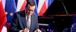 Premier Mateusz Morawiecki podpisuje dokument.