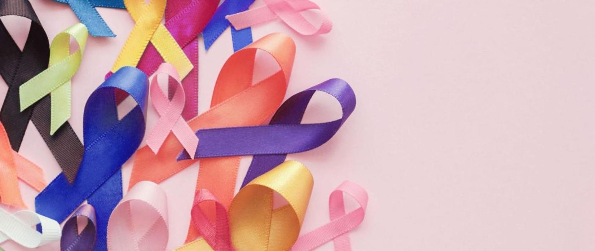 Zdjęcie kolorowych wstążeczek na różowym tle.