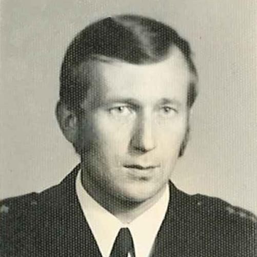 czarno-białe zdjęcie strażaka w mundurze w białej koszuli z krawatem
