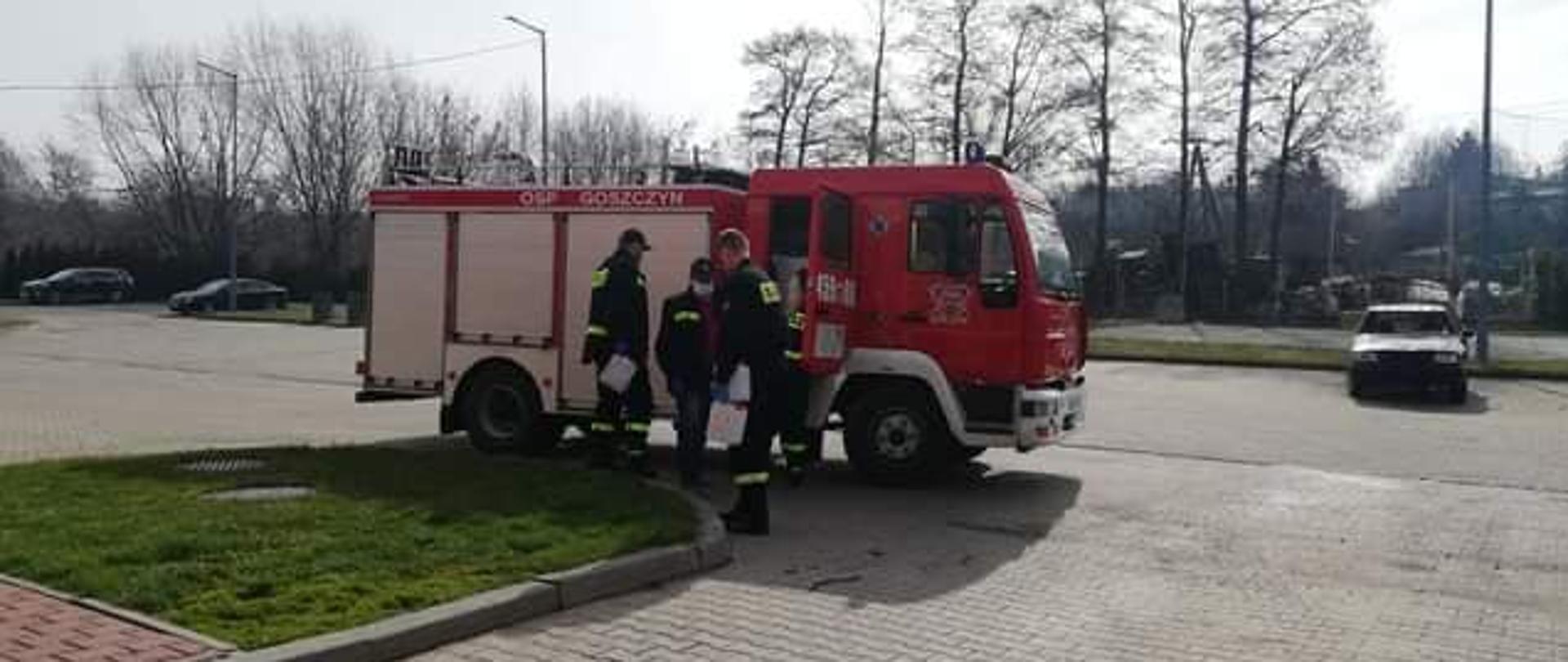 Dystrybucja parafie 2021, zdjęcie przedstawia strażaków ładujących środki ochrony osobistej do pojazdu pożarniczego.