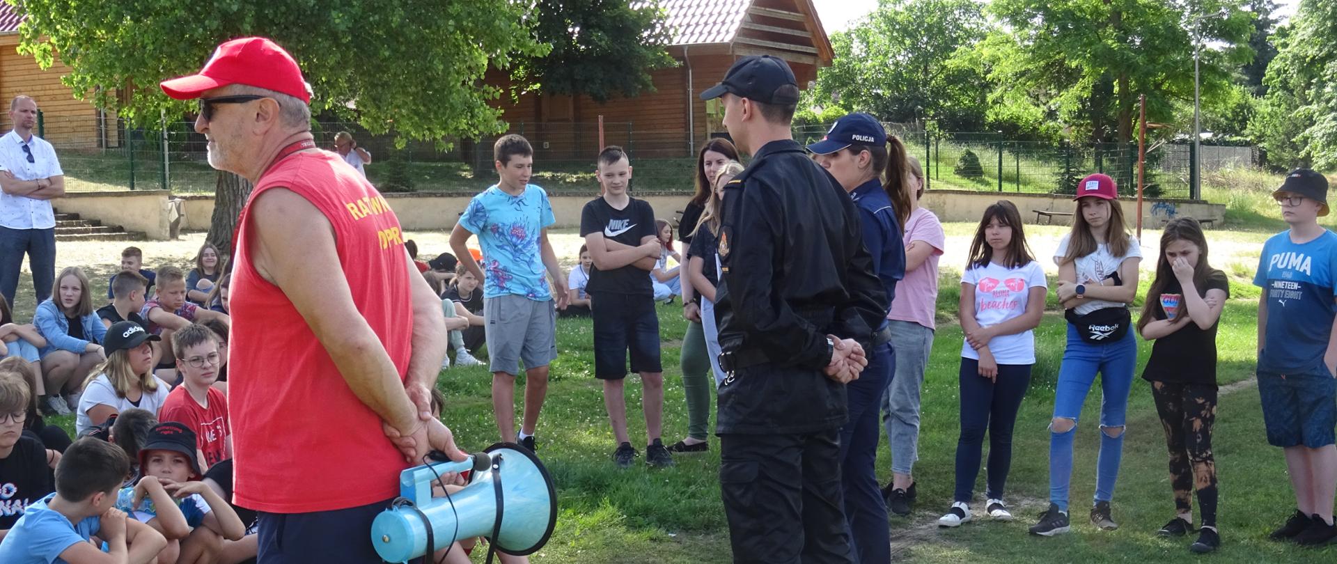 Na zdjęciu ratownik WOPR, strażak i policjantka opowiadają o bezpiecznych wakacjach.