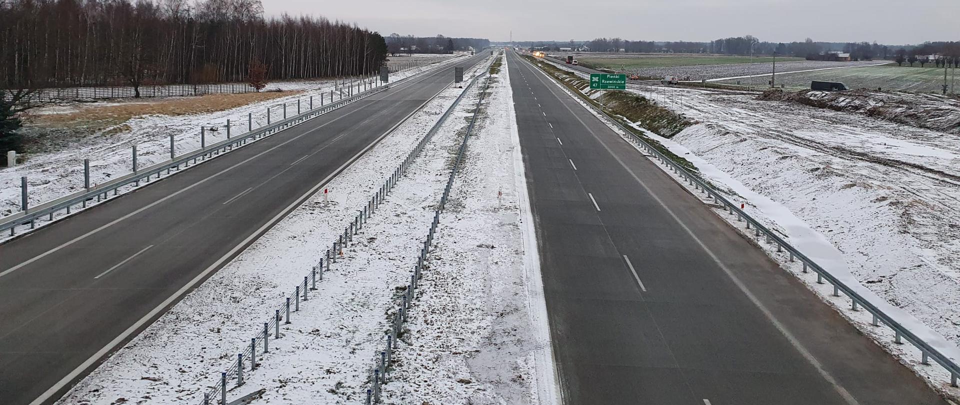 Droga ekspresowa po dwa pasy w obu kierunkach. Na poboczach i pasie rozdziału widoczny śnieg.