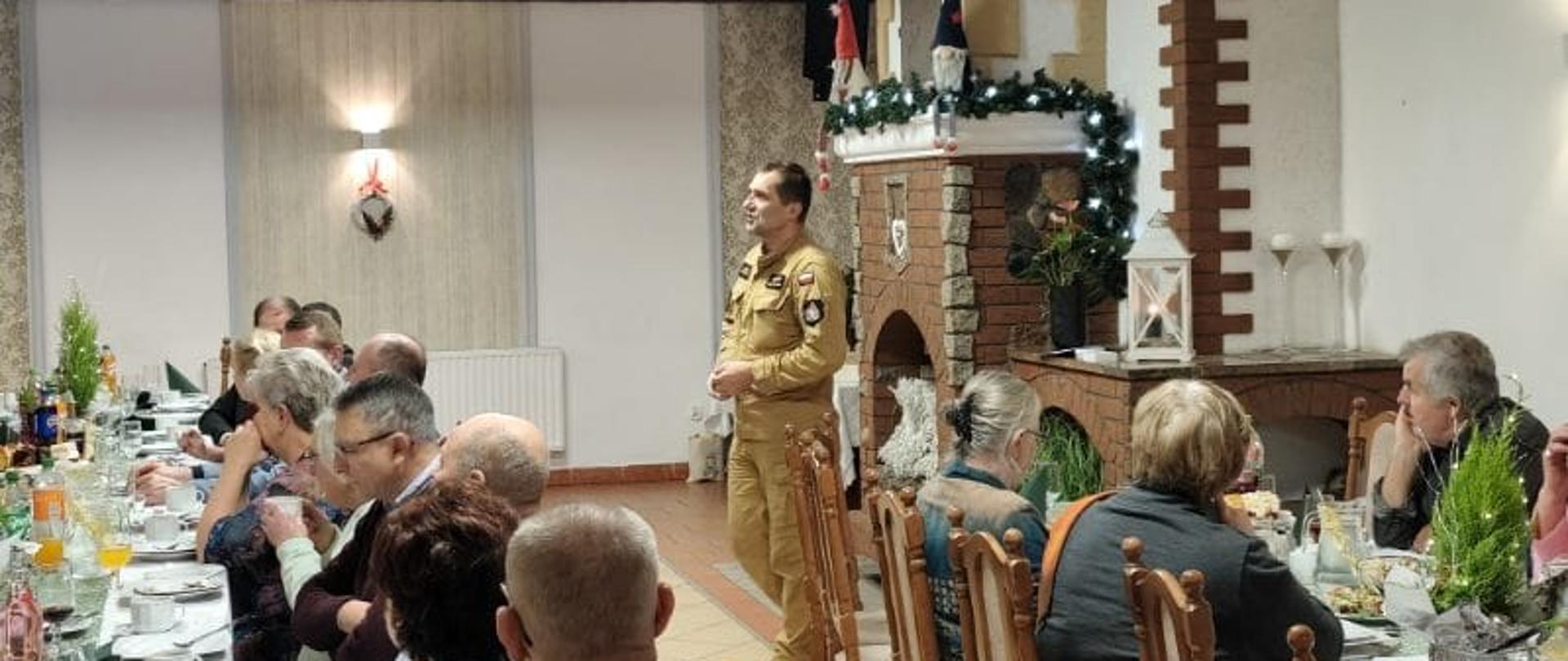 Zdjęcie przedstawia Dowódcę jednostki ratowniczo-gaśniczej z Kartuz podczas pogadanki na temat bezpieczeństwa pożarowego podczas wydarzenia dzień seniora